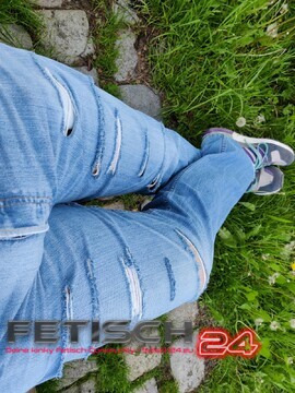 Ripped Jeans und Sneakers